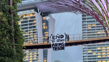 3 people holding up 'End Singapore-Israel arms trade' banner at Gardens by the Bay under probe
