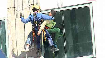 Worker rescued after being suspended from building