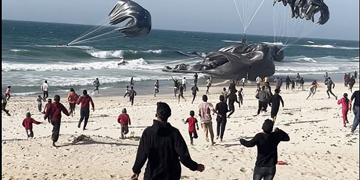 Images show Palestinians running toward food parcels attached to parachutes as US airdrops begin on Gaza beach