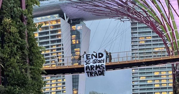 3 people holding up 'End Singapore-Israel arms trade' banner at Gardens by the Bay under probe