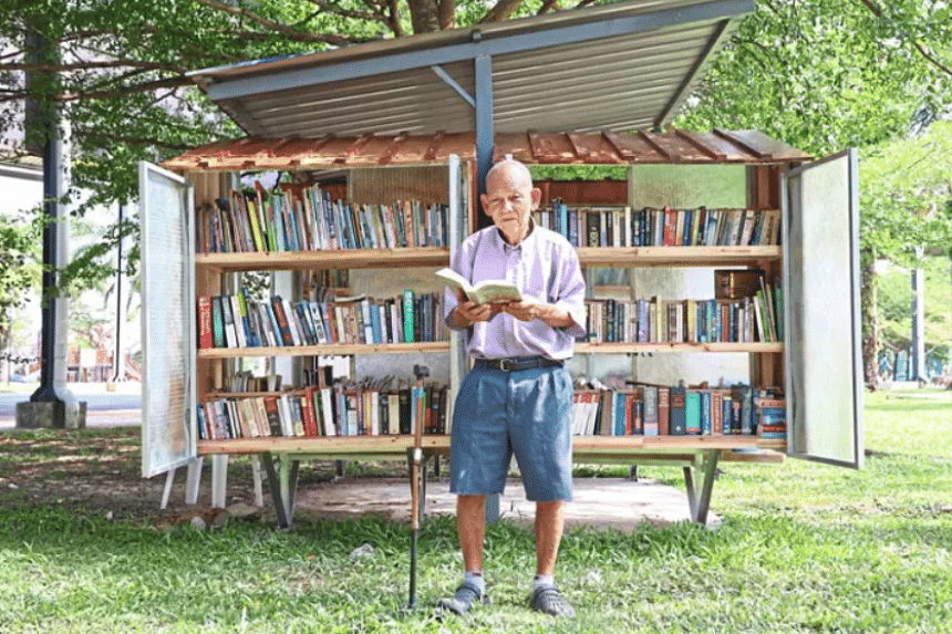 Elderly Malaysian man operates mini libraries in a park