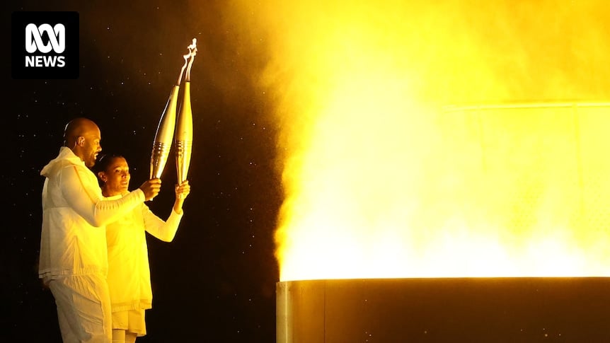 Who carried and who lit the flame during the 2024 Paris Olympics opening ceremony?