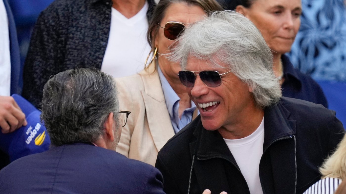 Jon Bon Jovi helps talk a woman off the ledge of a bridge while filming a music video