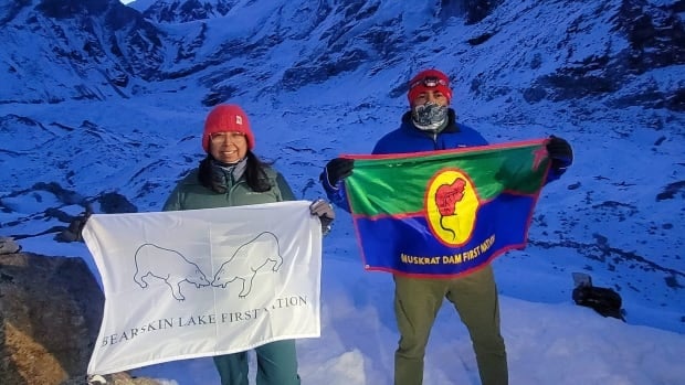 Couple from northwestern Ontario wave their First Nations' flags at Mount Everest's base camp