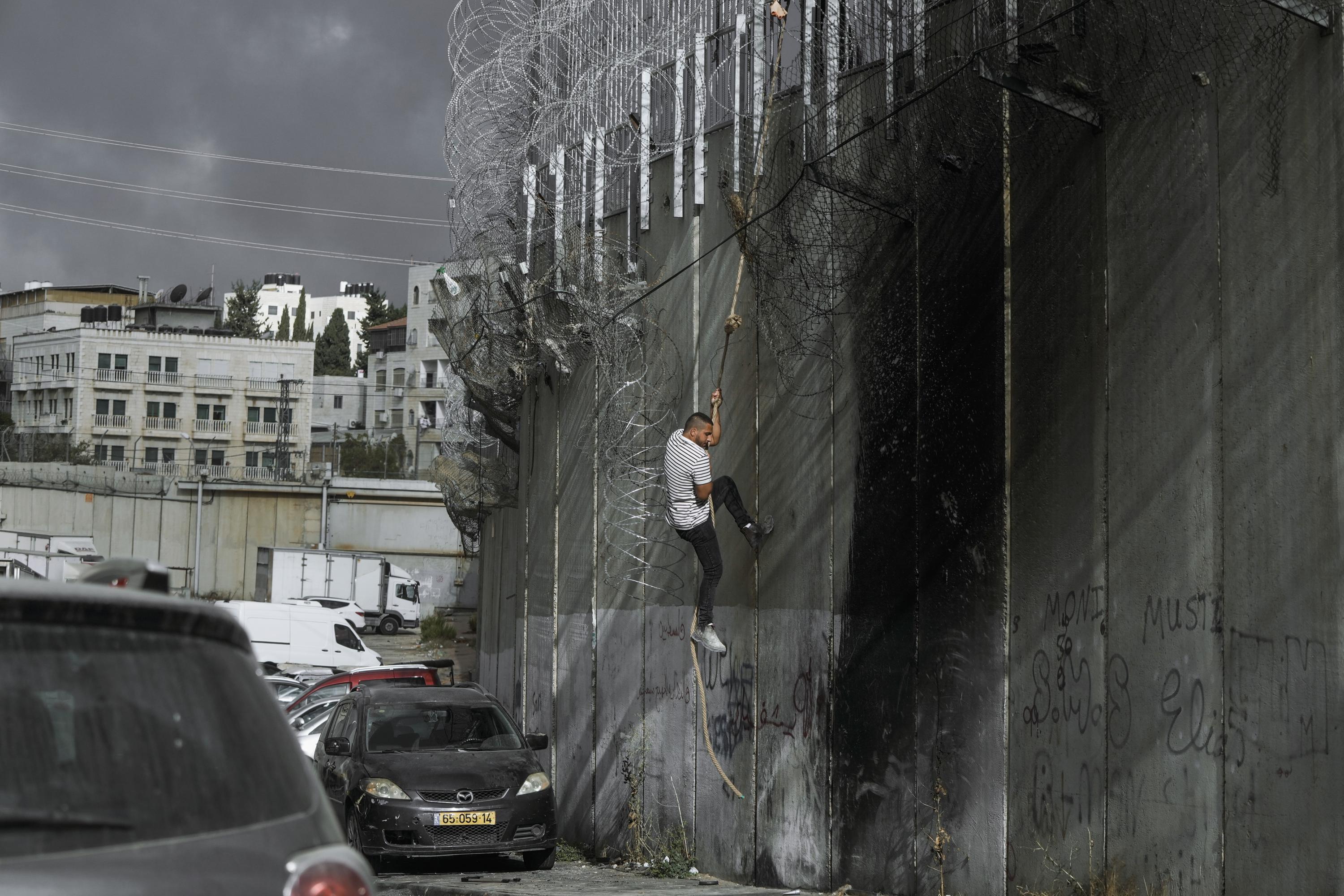 Palestinians in West Bank risk crossing Israel's separation barrier to flee failing economy