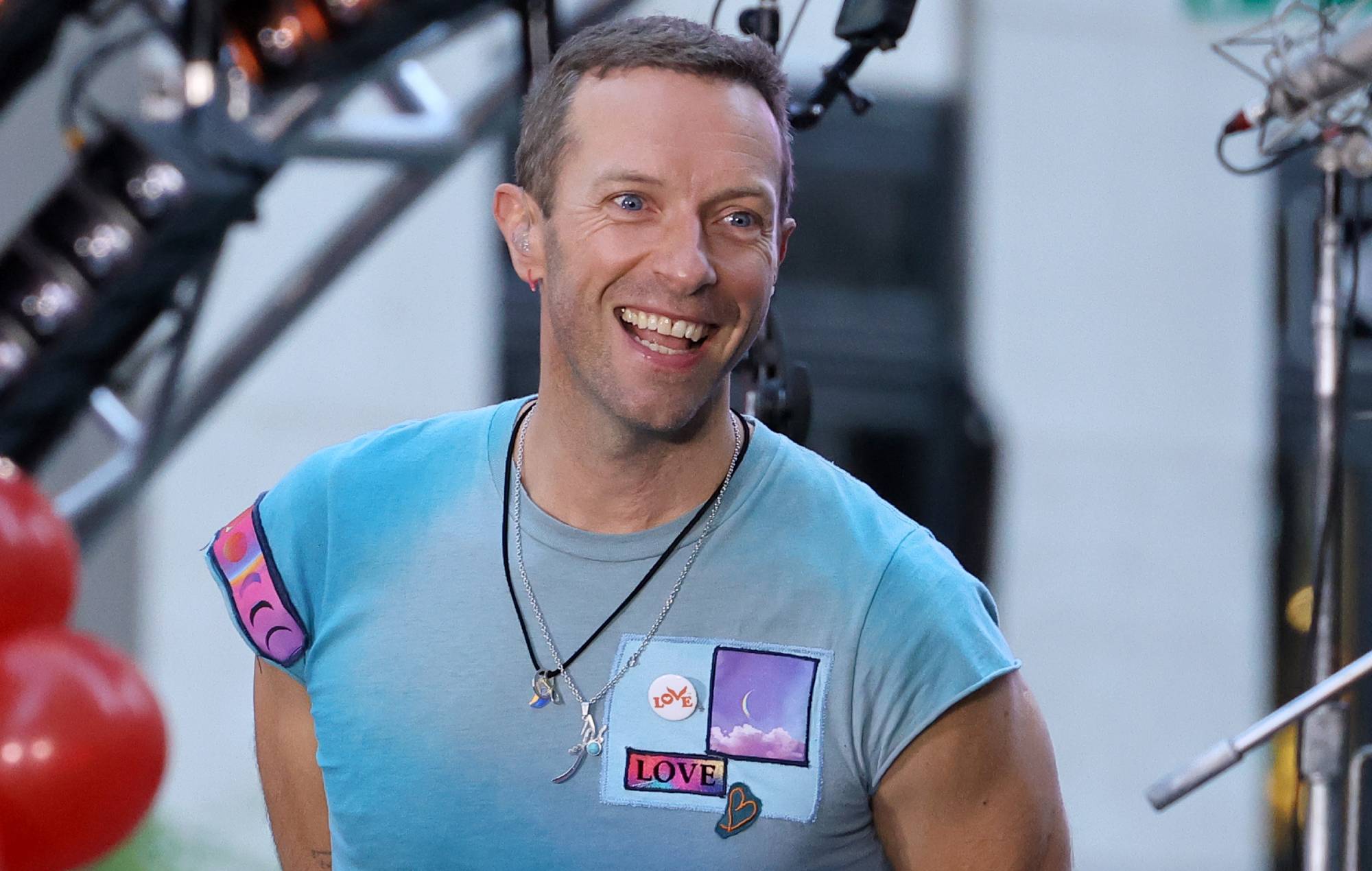 Chris Martin kisses tarmac before boarding plane in Sydney