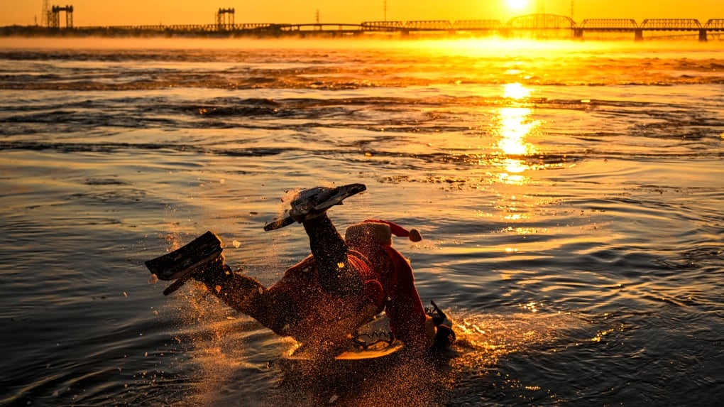 Ho! Ho! HOLY that's cold! Montreal boogie boarder in Santa suit hits St. Lawrence waters